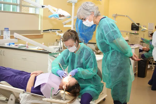 HANDS ON: Monitored by an instructor, a Hagerstown hygiene student tends to a classmate.