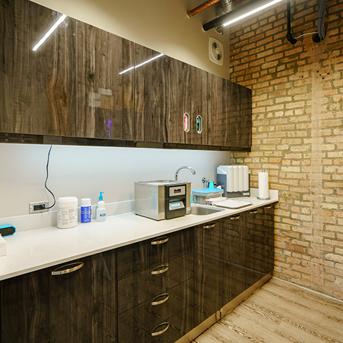 WHOSE WOODS THESE ARE: Dark cabinetry throughout, even in the sterilization area, provides a potent contrast to the walls and flooring.