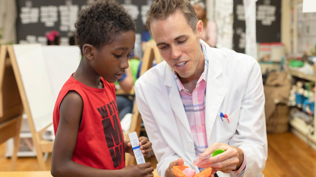 Dr. Tristan Hamilton, an architect and dentist who practices in North Carolina, with a student at the Ralph Bunche School