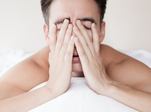 Man holding face because he has sleep apnea.