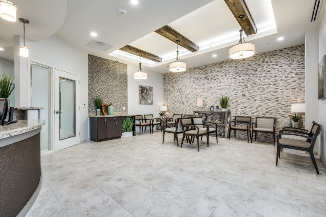 Layered lighting, muted colors and natural textures and materials are ideal for the reception area, for instance those at Lukin Family Dentistry, Sugar Land, Texas (shown).