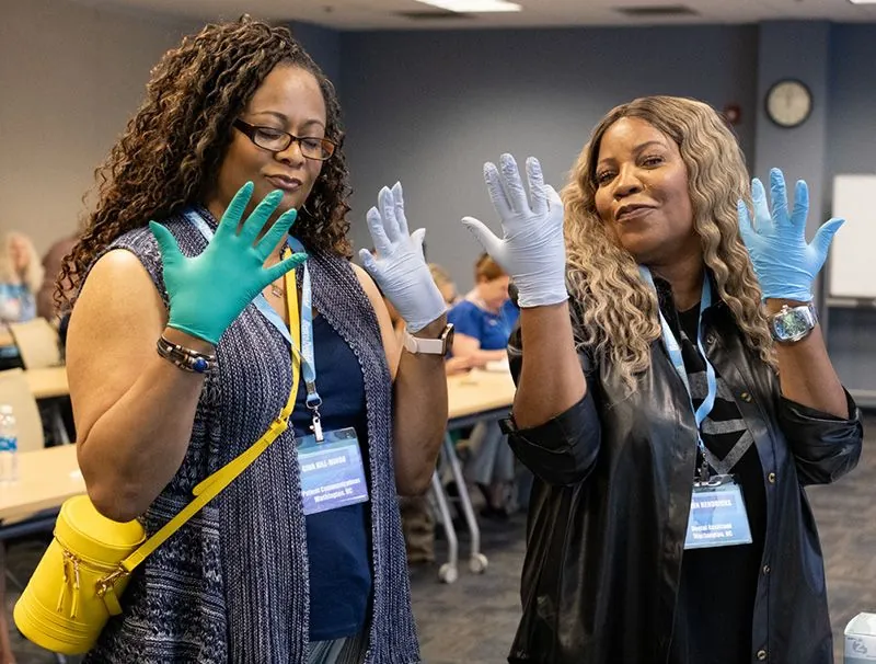 (from left) Gina Hill-Minor and Erin Hendricks show the gloves a little love;