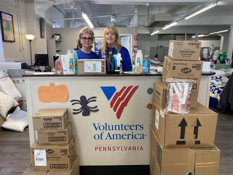 ADDED BOOST: Benco’s Booster Committee raised $932 through the sale of candy apples and mums, a total matched by the Benco Family Foundation. On World Smile Day, associates, including executive assistant Debby Wargo (left) and senior repairs experience specialist Lori Liparula, filled bags with personal care products, nonperishable food and other essentials. 